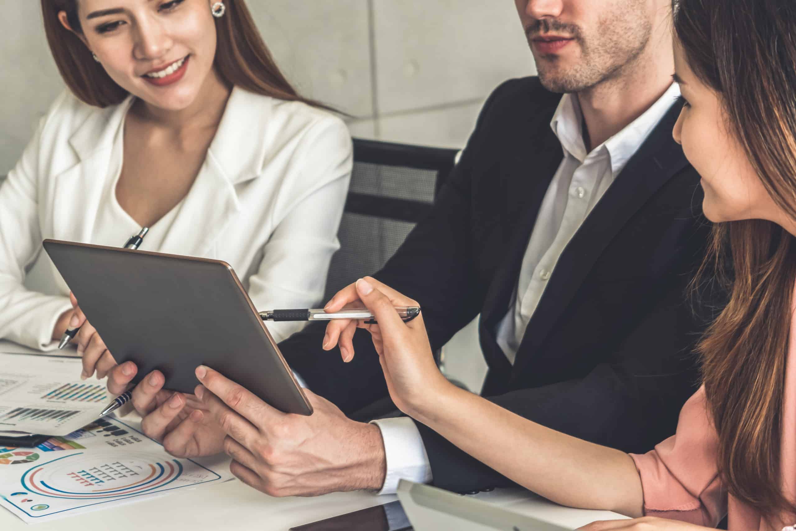 workers talking around an iPad